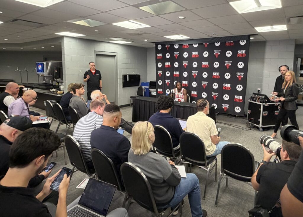 Reporters and photographers seated in front of Caleb Wilson at the podium during Bulls media day